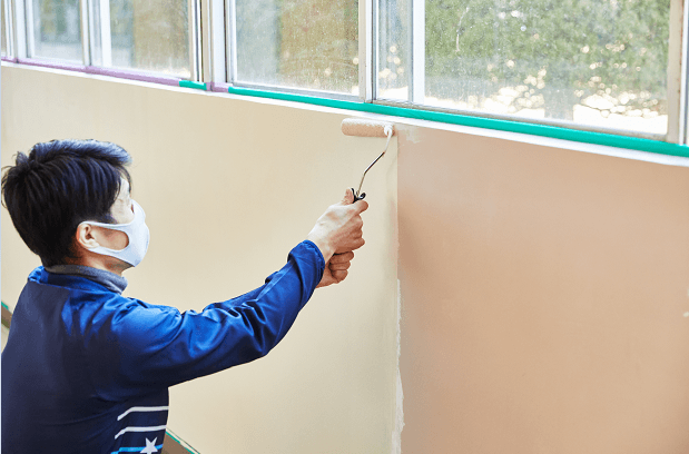 School employee applying the donated paint