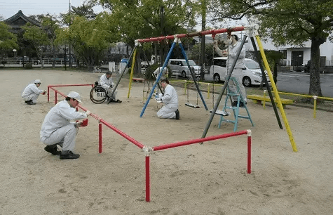 遊具に塗装を施す社員ボランティア